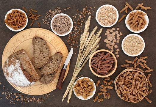 Bowls of pasta, grains, bread on a plate with knife