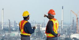 African American engineer is discussing on furture plan while looking over the petroleum and crude oil refinery factory for power industry