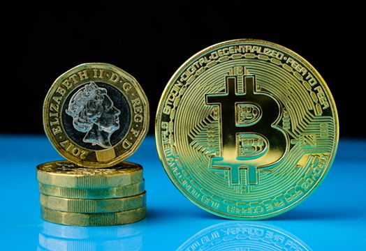 Pound coins next to a bitcoin