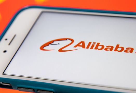 Alibaba Group - Alibaba set to report strong sales and profit growth for 1Q - Alibaba logo on iPhone in cart with Chinese flag