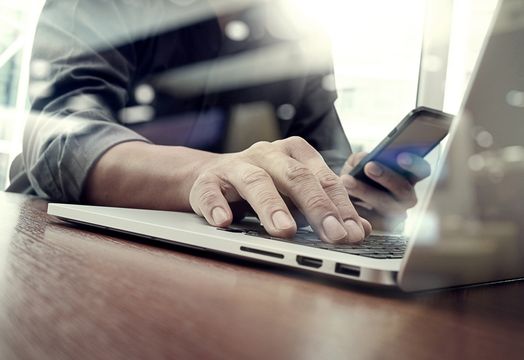 Person on phone and laptop