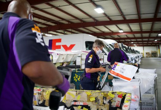 FedEx  workers and vehicles and packages