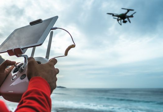 Male engineer doing inspection using drone while wearing face mask to avoid corona virus spreading - Technology and industrial concept